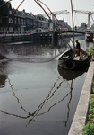 849824 Afbeelding van een visser met zijn vissersboot in de Leidsche Rijn te Utrecht, ter hoogte van houthandel De Wit. ...